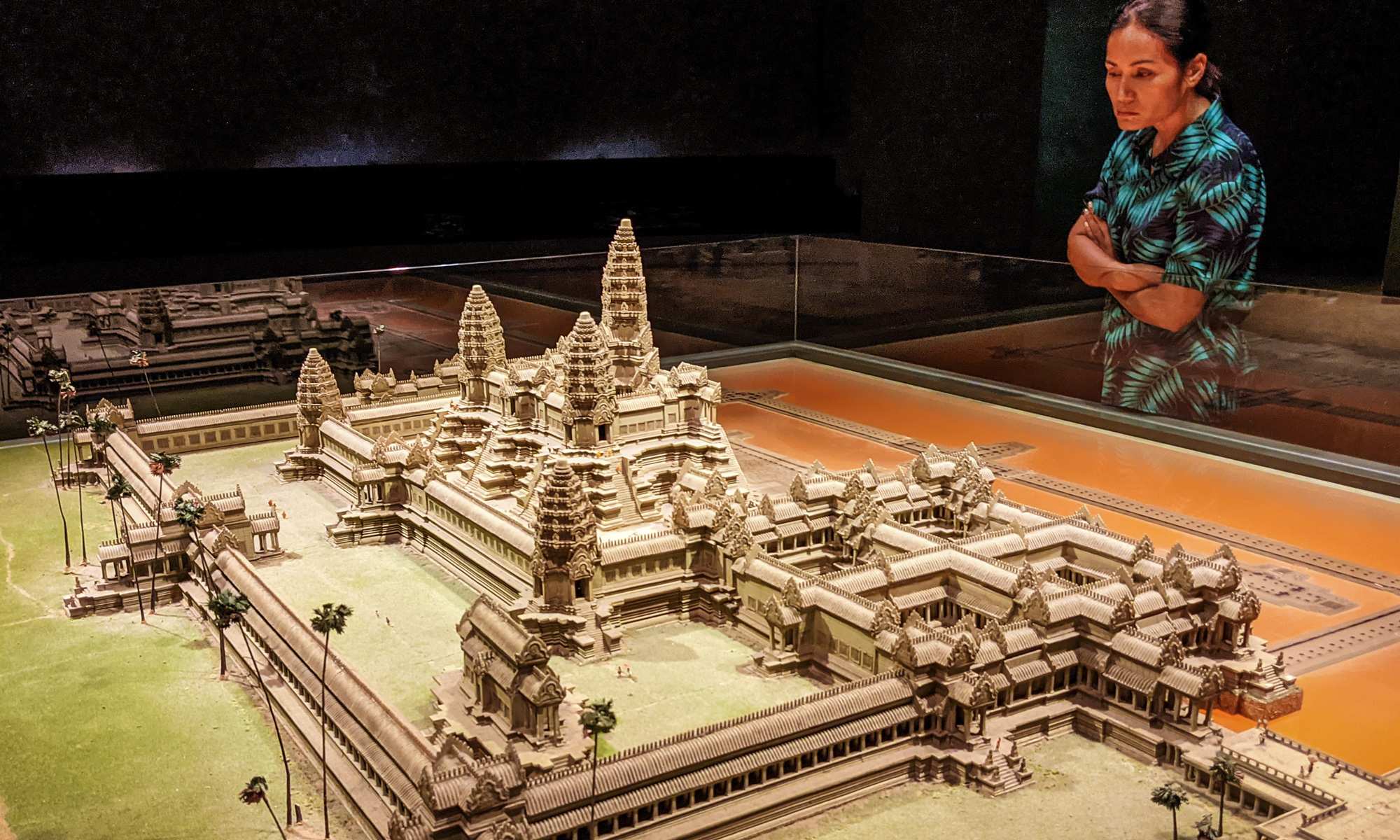 A woman looking at a model of Angkor Wat
