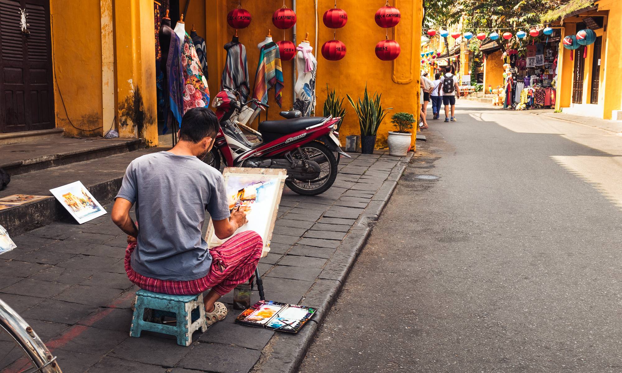 Man painting on the sidewalk of Hoi An, Vietnam