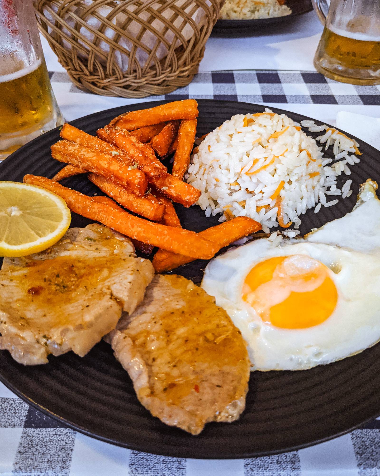 A dinner on the Portuguese Camino de Santiago of rice, sweet potato fries, pork, and an egg
