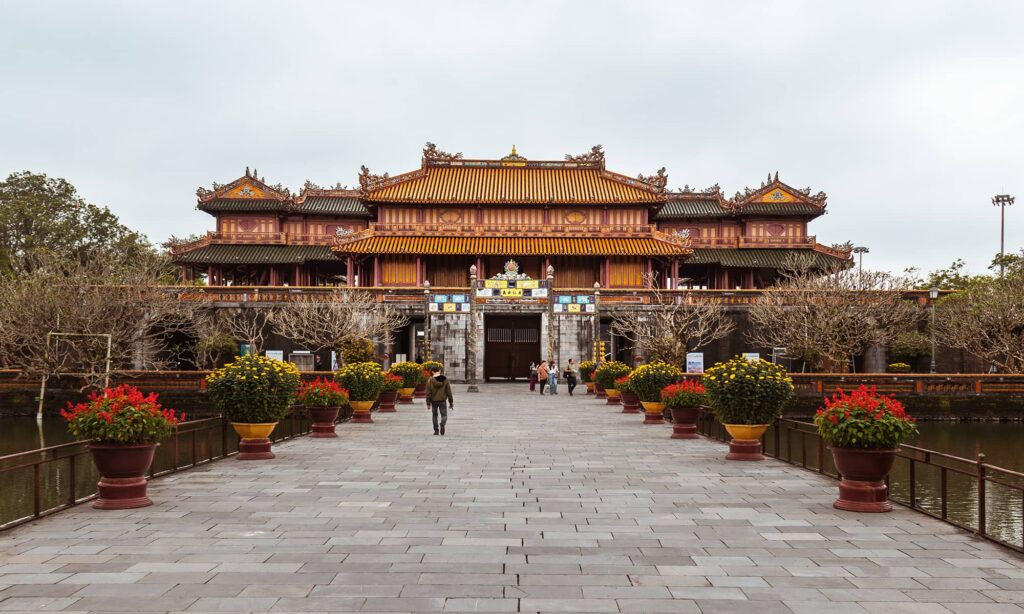Tourists on a stone walkway leading to the gates of Hue Historic Citadel during Tet