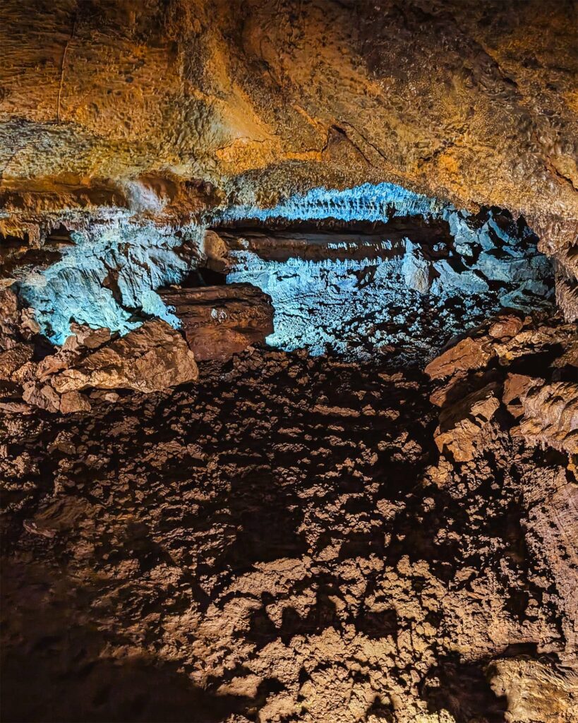 Cave tunnel entrance in Gruta do Carvao lit by blue light